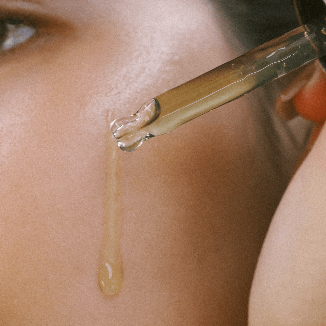 Close-up of a dropper applying Serum of Clear to skin